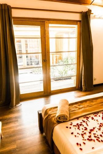 a bedroom with a bed and a large window at RISING SUN BEACH VIEW in Thinadhoo