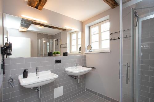 La salle de bains est pourvue de 2 lavabos et d'une douche. dans l'établissement Wertschätzer Hotel - Krumme Str, à Detmold
