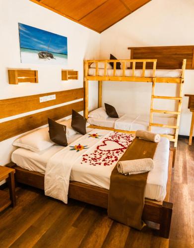 a bedroom with two bunk beds and a table at RISING SUN BEACH VIEW in Thinadhoo