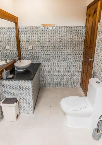 a bathroom with a toilet and a sink at RISING SUN BEACH VIEW in Thinadhoo