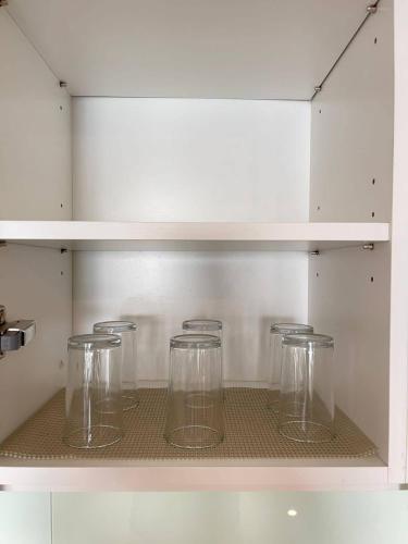 a row of glass jars sitting on a shelf at Teega Suites Seaview by VDO Homestay in Nusajaya