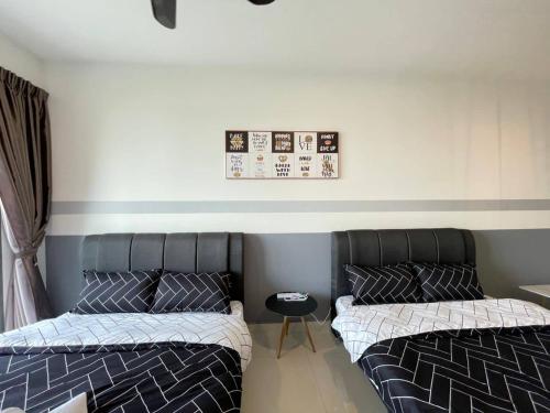 two beds sitting next to each other in a room at Teega Suites Seaview by VDO Homestay in Nusajaya