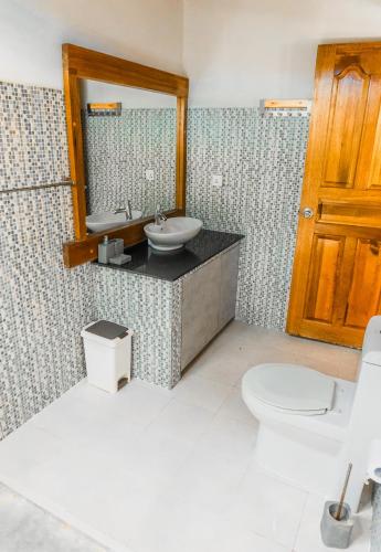 a bathroom with a sink and a toilet and a mirror at RISING SUN BEACH VIEW in Thinadhoo