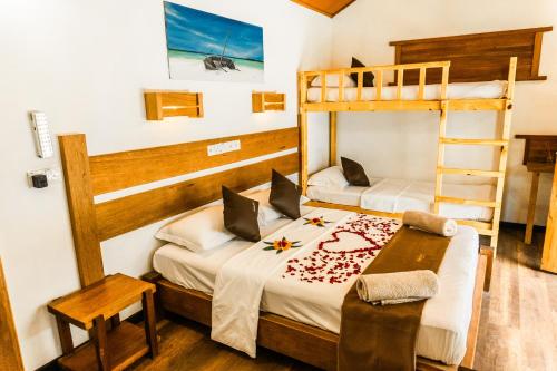 a bedroom with two bunk beds and a desk at RISING SUN BEACH VIEW in Thinadhoo