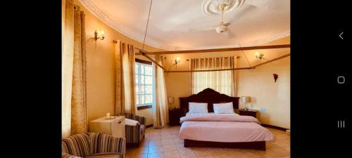 1 dormitorio con 1 cama y 1 silla en SALAAM LETTING (4 BEDROOM, ZANZIBAR HOUSE), en Kiembi Samaki