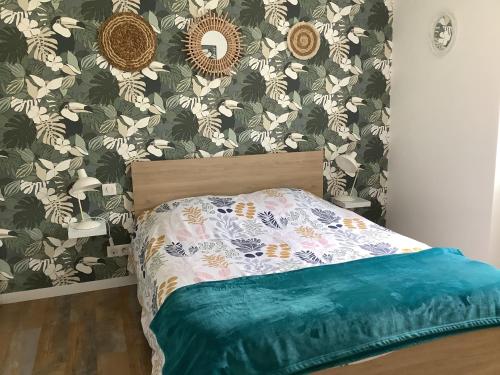 een slaapkamer met een bed met bloemenbehang bij Les Bruyeres in Concarneau