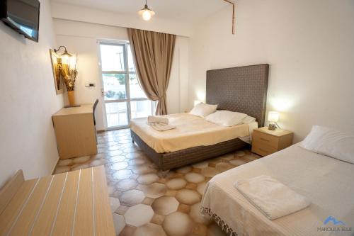 a hotel room with two beds and a window at Casa Blue Sarantis in Faliraki