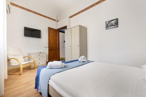 biała sypialnia z łóżkiem i krzesłem w obiekcie Porta Carini w mieście Palermo