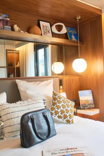 a purse sitting on a bed in a room at CARD Hôtel in Paris