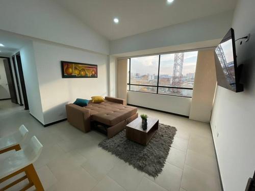 ein Wohnzimmer mit Couch und großem Fenster in der Unterkunft Encantador apartamento #3 cerca al aeropuerto in Bogotá