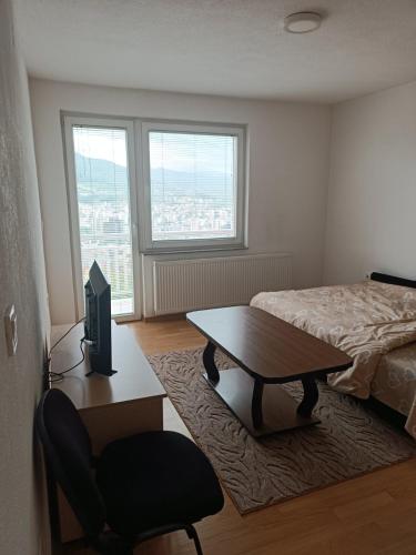 2BDR Apt with Balcony with view- Free Parking في سراييفو: غرفة نوم بسرير وطاولة وكرسي