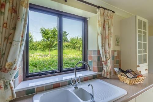 a kitchen with a sink and a window at Keepers Cottage in Fakenham