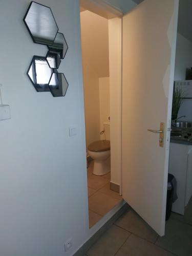 une salle de bain avec toilettes et une lumière au mur dans l'établissement Studio 10 min aéroport orly, à Athis-Mons