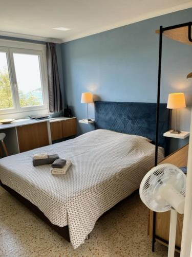 - une chambre avec un lit, une chaise et deux fenêtres dans l'établissement La roche aux mouettes Ile du Levant, sur l'Île du Levant