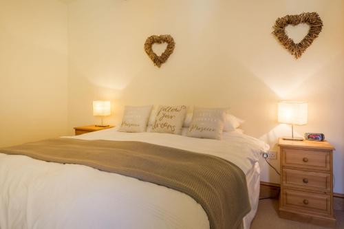 a bedroom with a bed with two hearts on the wall at Geddings Farm Barn in Ringstead