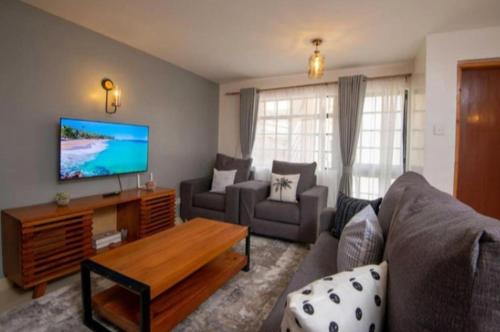 un soggiorno con divano e TV di Phase 2 a Nairobi