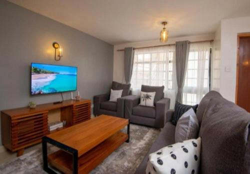 un soggiorno con divano e TV di Phase 2 a Nairobi