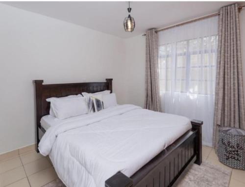 una camera con un grande letto e una finestra di Phase 2 a Nairobi