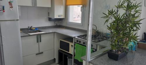 cocina con armarios blancos y fogones en Hermoso departamento en Mar del Plata en Mar del Plata