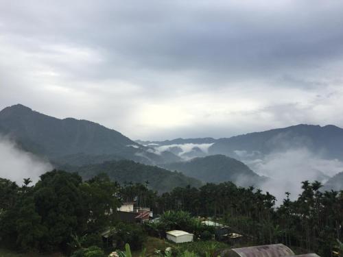a misty mountain valley with a town in the foreground at Yong Li Hotel in Gukeng