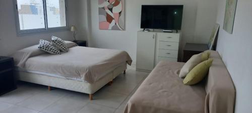 1 dormitorio con cama, sofá y TV en Hermoso departamento en Mar del Plata en Mar del Plata