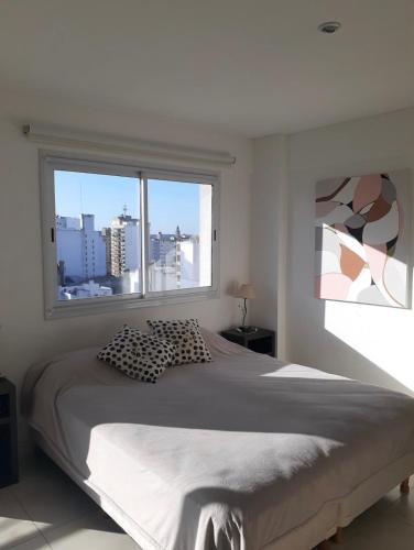 1 dormitorio con cama grande y ventana grande en Hermoso departamento en Mar del Plata en Mar del Plata