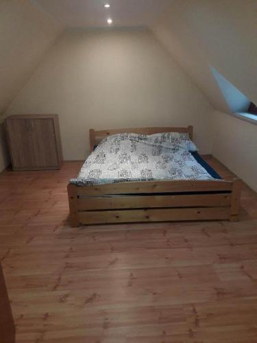 a bedroom with a wooden bed in a attic at Domek w Dolinie Zimnika in Lipowa