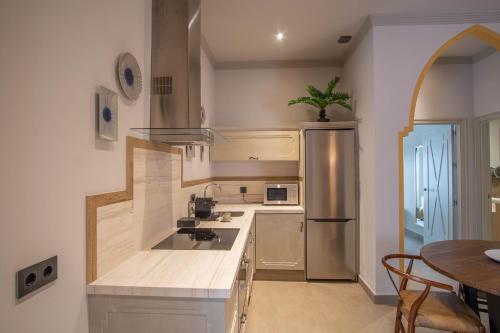 a kitchen with a sink and a refrigerator at Apartamentos Turísticos La Baílla in Rota