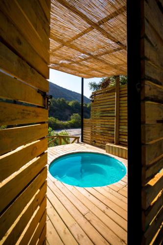 a swimming pool on a wooden deck with a wooden pergola at Haiku Cabañas Panorámicas in San José de Maipo