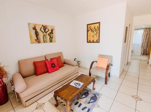 a living room with a couch and a table at Golden Candle Guest House in Roodepoort