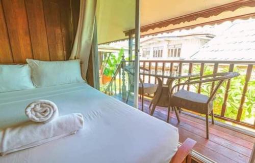 a bedroom with a bed and a balcony with a table at MANDARIN LODGE by victor in Hua Hin