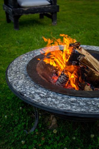 a fire pit on a table in the grass at Haiku Cabañas Panorámicas in San José de Maipo