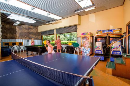 a group of children playing ping pong in a room at NRMA South West Rocks Holiday Park in South West Rocks