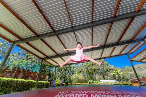 a girl jumping in the air on a trampoline at NRMA South West Rocks Holiday Park in South West Rocks