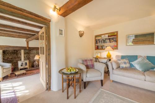 a living room with a couch and a table at Brooke Cottage in Little Walsingham