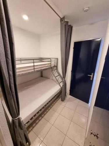 Cette petite chambre comprend des lits superposés. dans l'établissement En bord de mer, avec Grande terrasse et Climatisation, au Grau-du-Roi