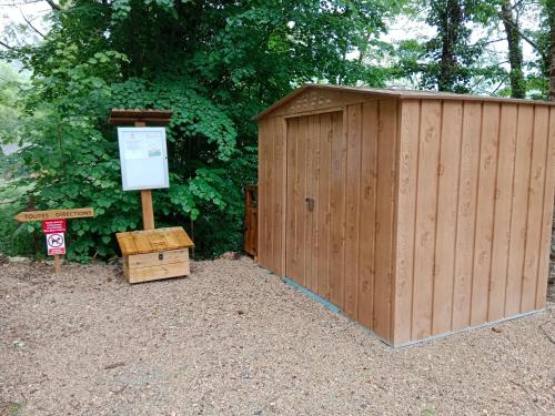 a wooden shed with a sign in front of it at les gites axéens (l'Ours) in Ax-les-Thermes