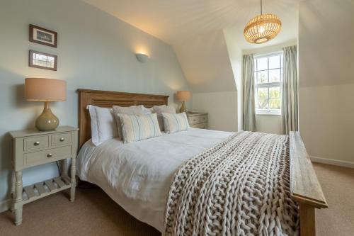 a bedroom with a large bed and a window at Forge Cottage in Thornham