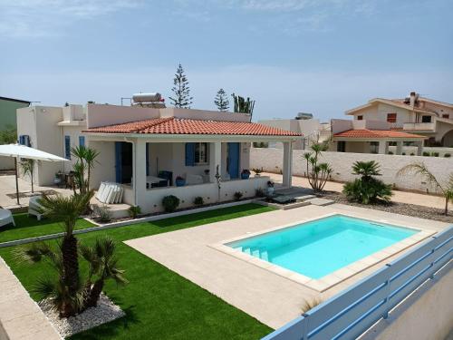 een villa met een zwembad en een huis bij Villa Colapesce in Marzamemi