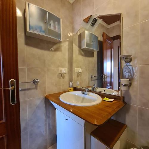uma casa de banho com um lavatório e um espelho em piso en noia em Noya