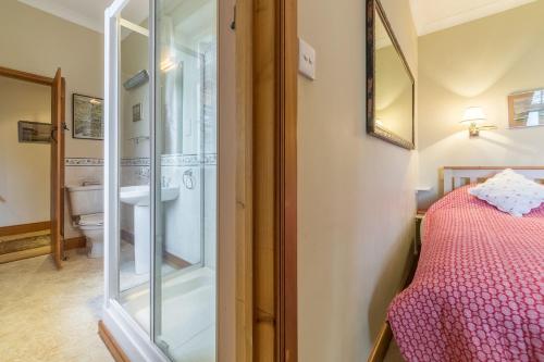 a bathroom with a shower and a bed in a room at Grooms Cottage C in Grimston