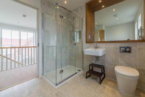 a bathroom with a shower and a toilet and a sink at Anchorage in Brancaster