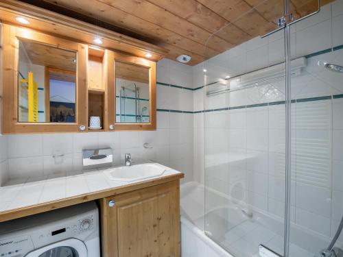 une salle de bain avec douche et lavabo et une machine à laver dans l'établissement Appartement moderne proche pistes avec accès piscine et spa - FR-1-566-53, à Les Allues