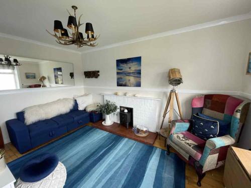 a living room with a blue couch and a fireplace at Todday Snug Self Catering Studio in Ersary