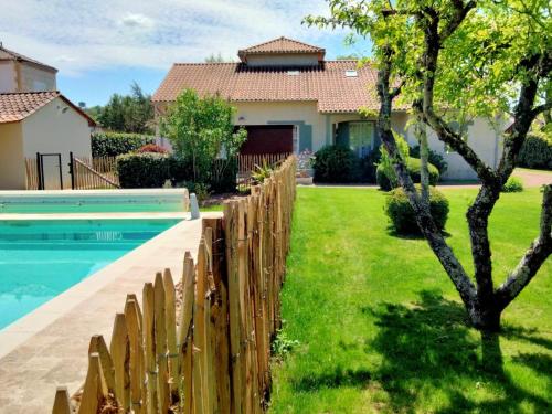 une clôture à côté d'une cour avec une piscine dans l'établissement Maison familiale avec piscine privée, proche de Périgueux, animaux acceptés - FR-1-616-236, à Chancelade