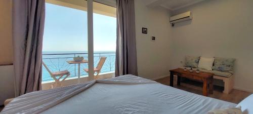 1 dormitorio con cama y vistas a un balcón en Beleri House, en Himare