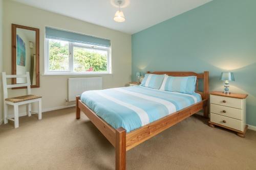 a bedroom with a large bed and a window at Sea Wind in Brancaster