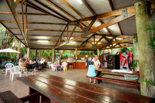 a group of people sitting in a patio with a bench at NRMA South West Rocks Holiday Park in South West Rocks