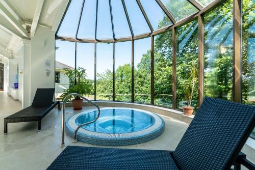 bañera de hidromasaje en un salón acristalado con techo de cristal en The Mole Resort - Lodges en Chittlehamholt