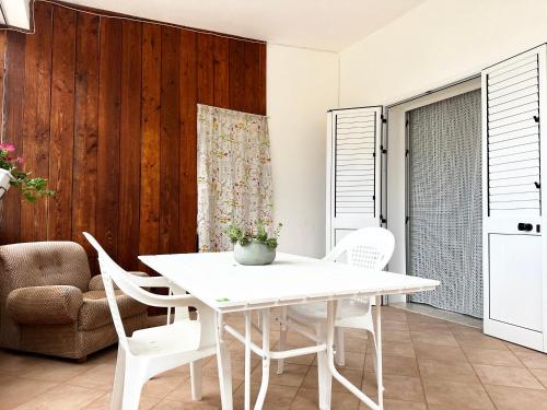 ein weißes Esszimmer mit einem weißen Tisch und Stühlen in der Unterkunft Appartamenti Castellammare del Golfo Milazzo Annarita in Castellammare del Golfo